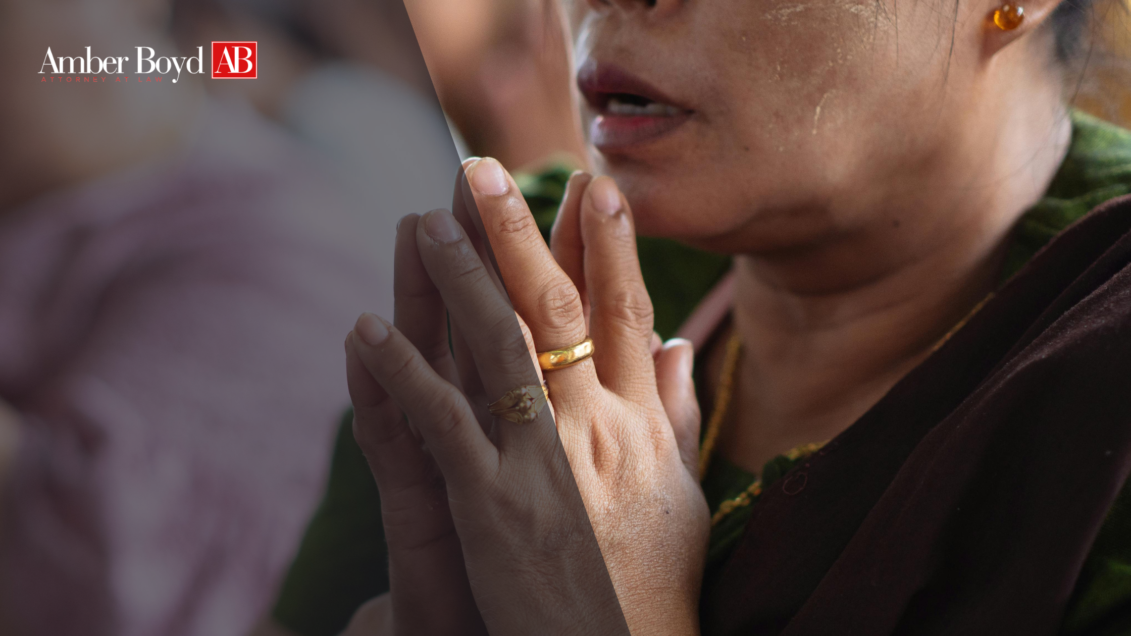 Close-up of hands pressed together in prayer with gold rings, partial face of a woman in background; Amber Boyd logo appears top-left.