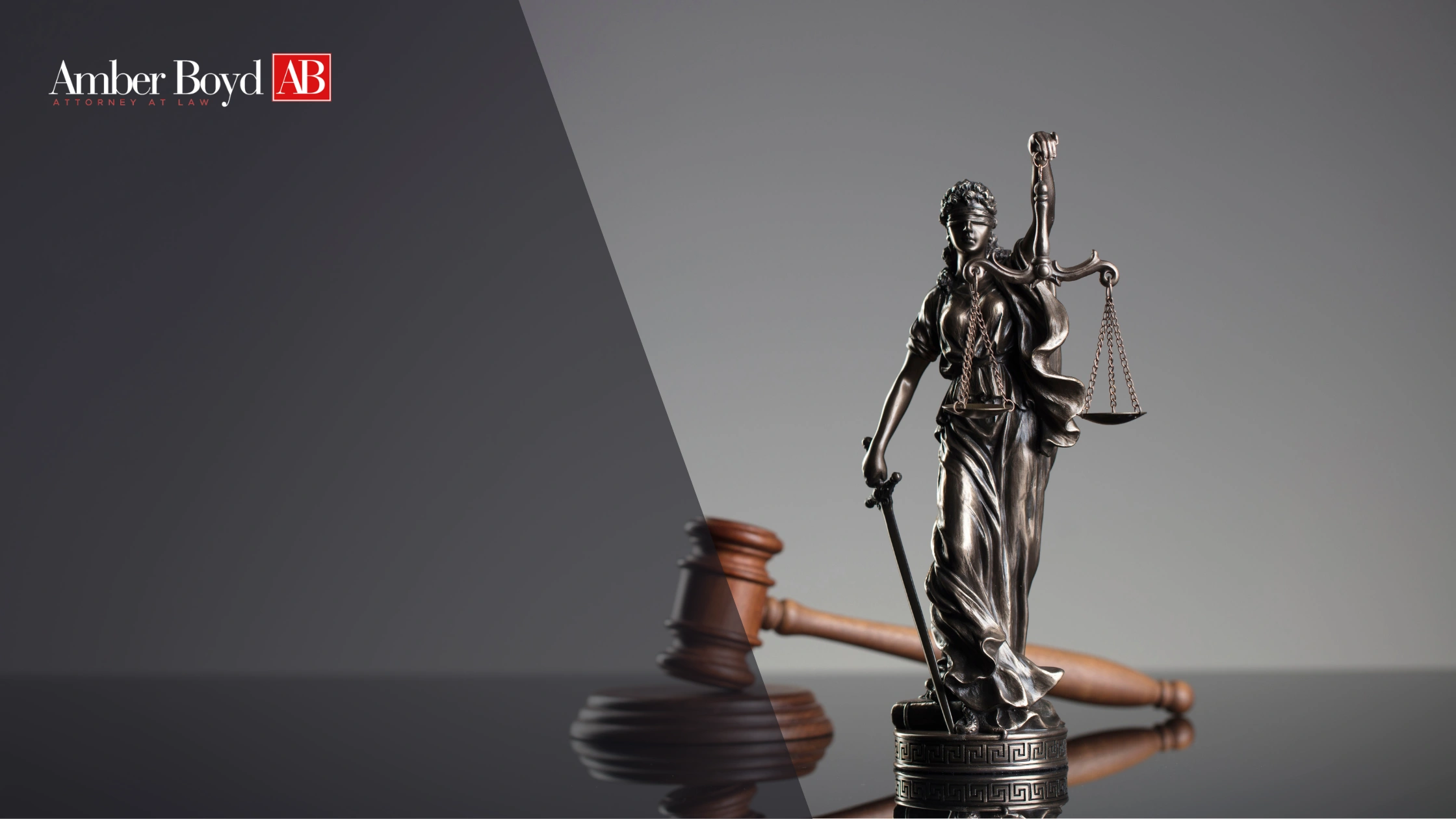 Statue of Lady Justice with scales and sword beside a gavel, against a split dark-gray background with Amber Boyd AB Attorney at Law logo on the left.