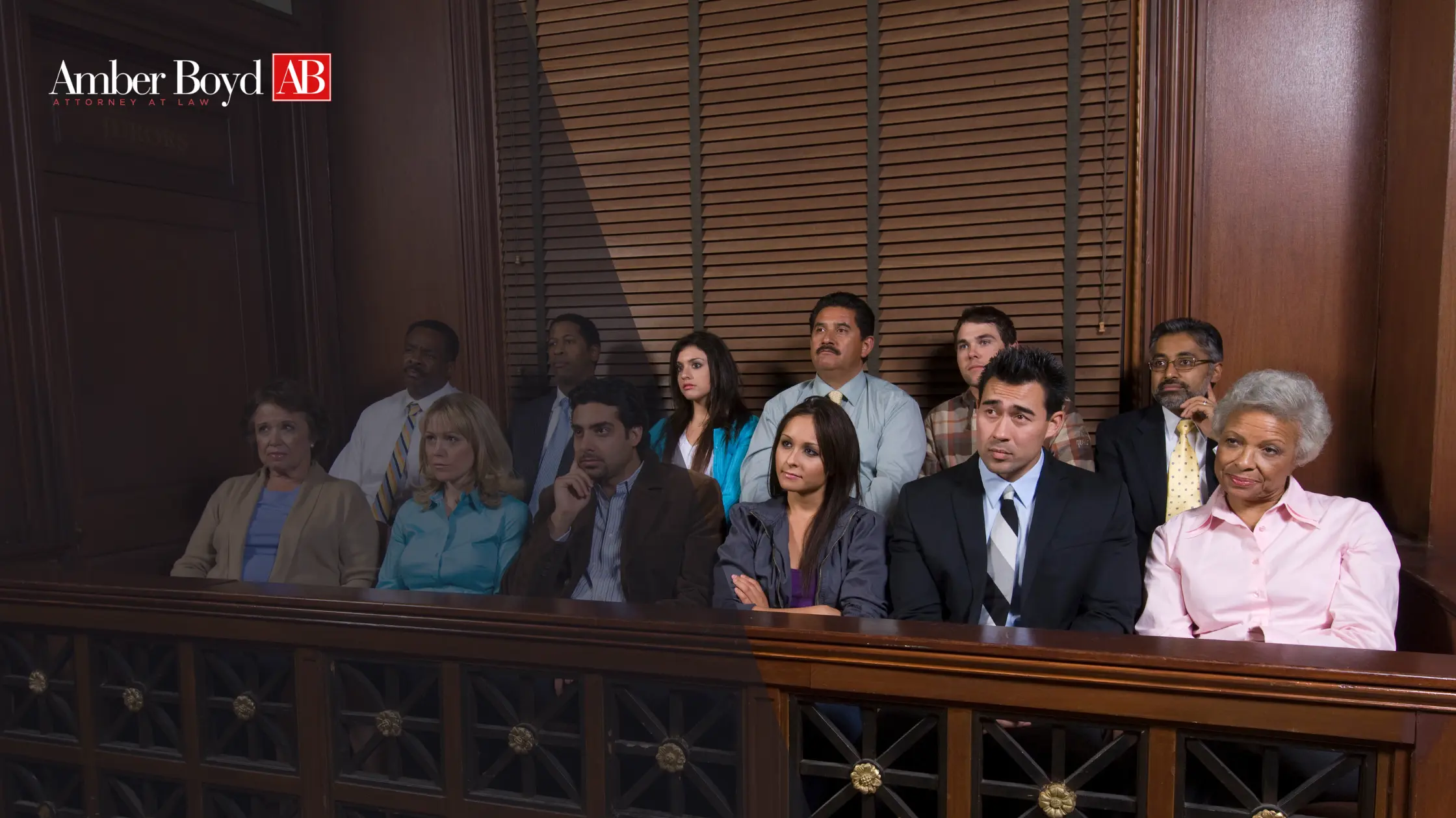 Group of diverse people seated in a courtroom gallery, with Amber Boyd AB Attorney at Law logo in the top-left corner.