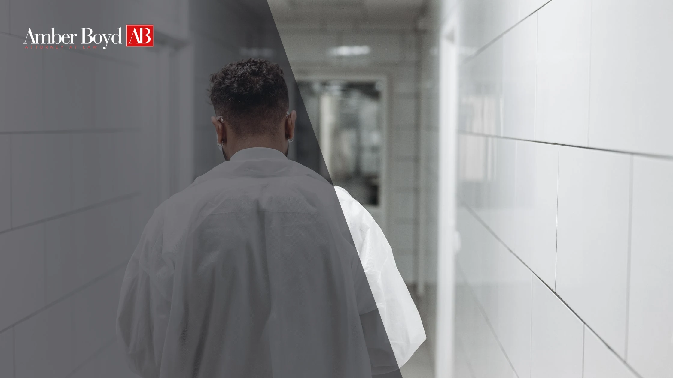 Person seen from behind wearing a white shirt, walking down a tiled hallway with a dark overlay and Amber Boyd AB logo in the top-left corner.