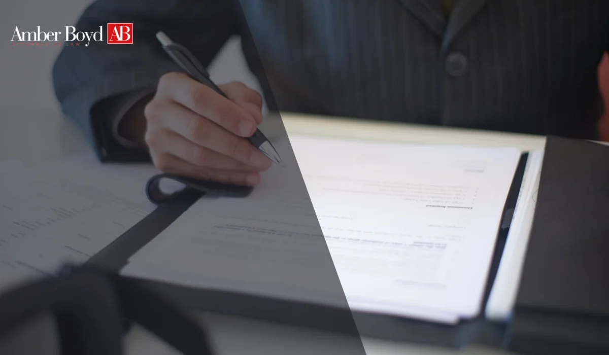 Person in a suit signing an employment contract at a desk