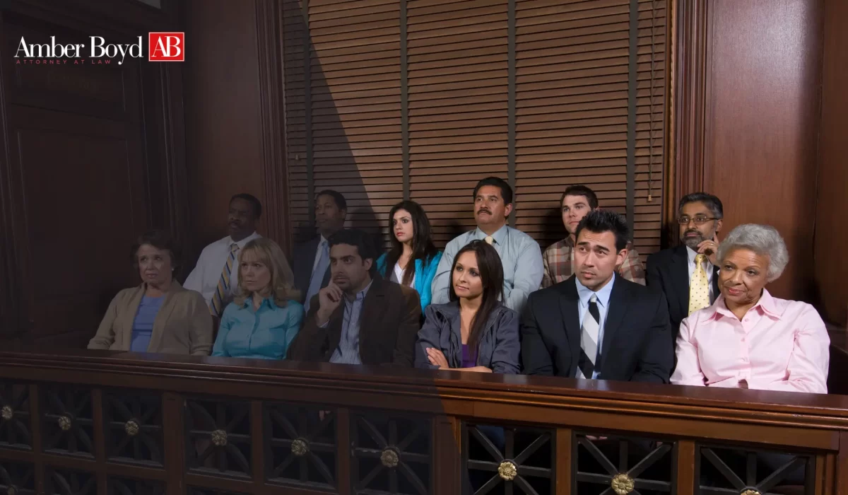 Group of diverse people seated in a courtroom gallery, with Amber Boyd AB Attorney at Law logo in the top-left corner.